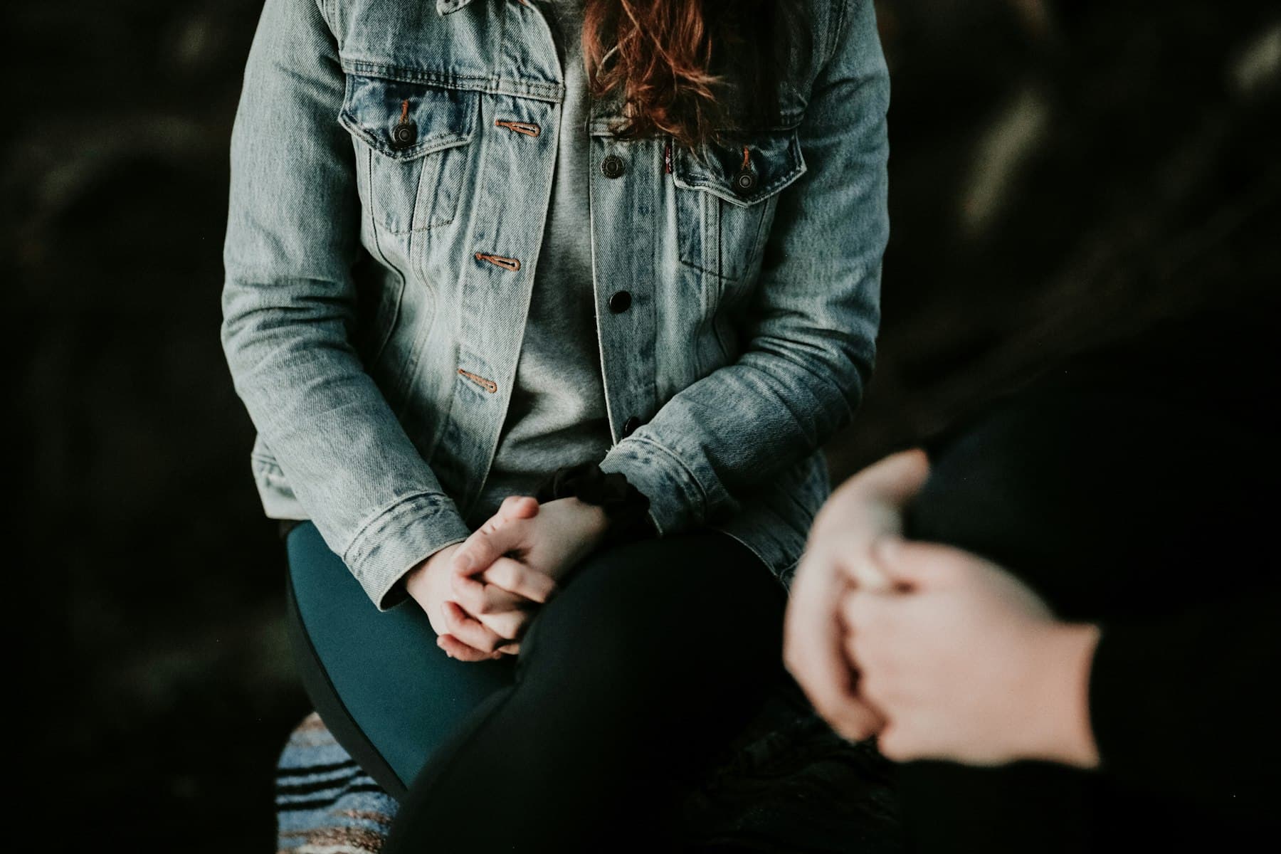 Counsellor sitting calmly, dressed in a soft grey jacket